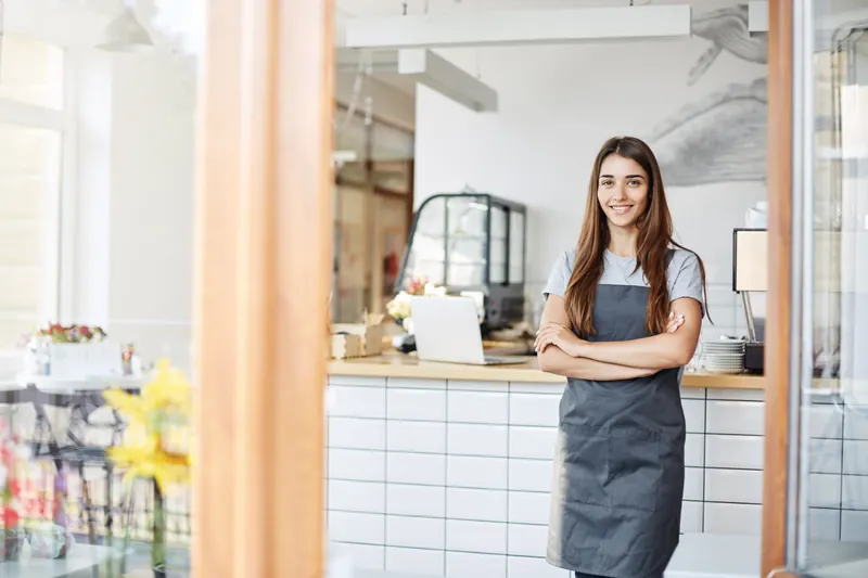 Entrepreneur wearing an apron in her small café