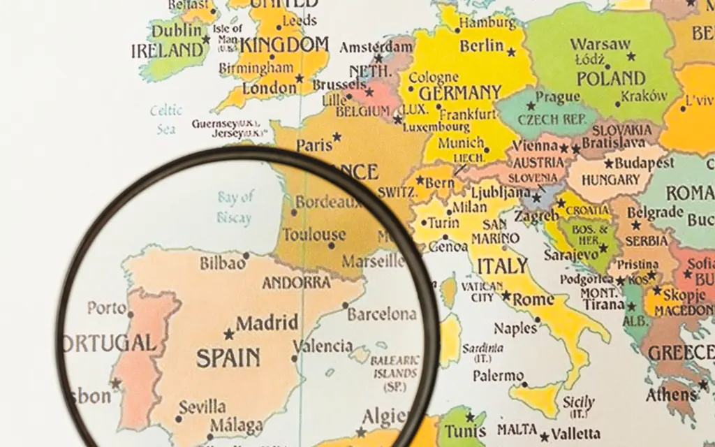 Una lupa señala España en un mapa de Europa