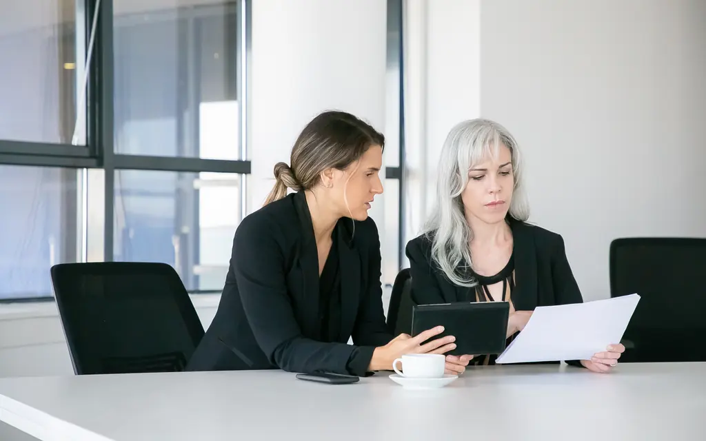 Dos profesionales revisan informes con una tableta